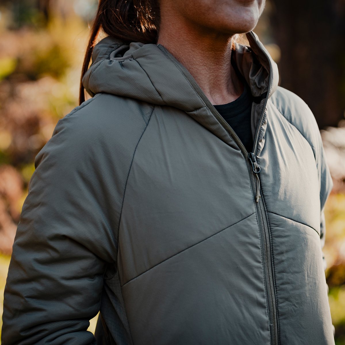 Close-up of the Spika Aura women's Dusky Green puffer jacket worn outdoors, showing hood and zip
