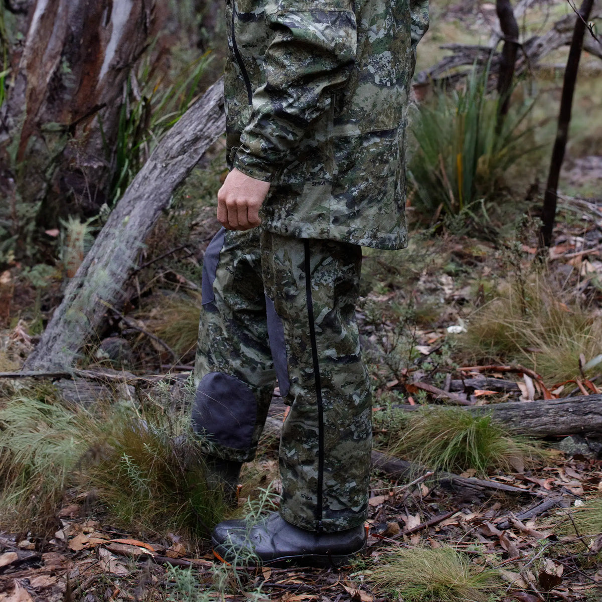 Hunter standing in the bush wearing Spika Edge Biarri Camo waterproof pants and matching jacket