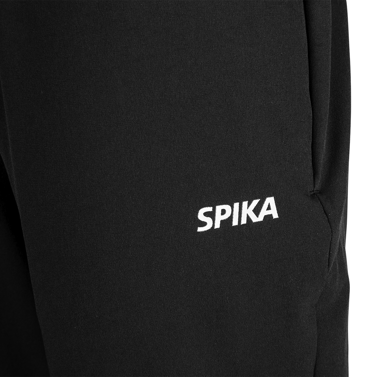 Close-up of the white SPIKA logo on the front thigh of Spika GO Casual women's black jogger pants