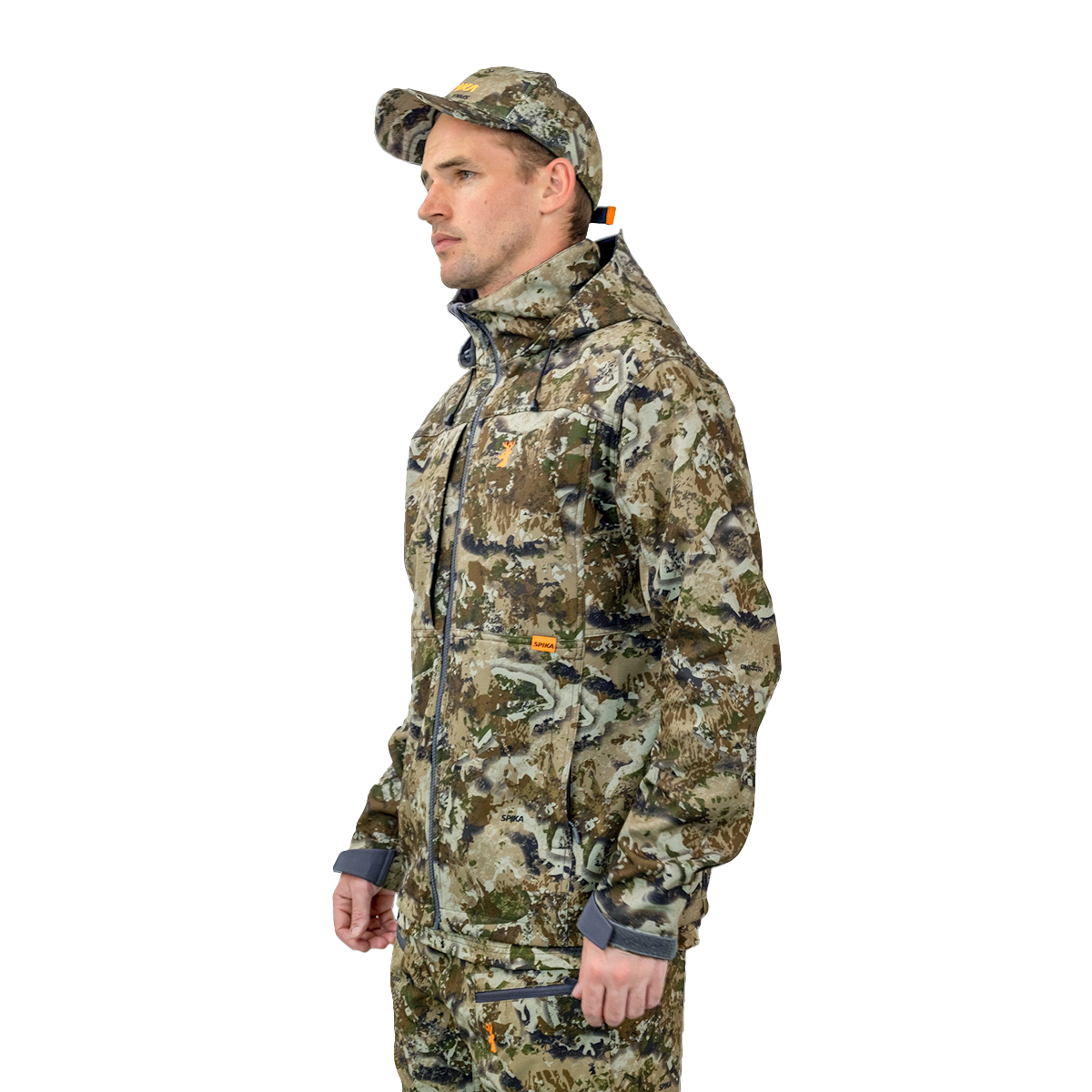 Man wearing the Spika Highpoint men's shell jacket in Biarri Camo, three-quarter view with cap