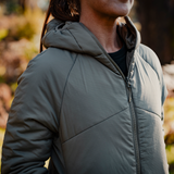 Close-up of the Spika Aura women's Dusky Green puffer jacket worn outdoors, showing hood and zip