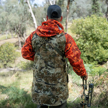 Bowhunter in the Spika Valley men's jacket in Biarri Camo/Blaze seen from behind in the bush