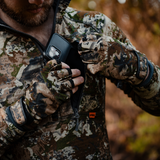 Hunter wearing Spika Precision fingerless gloves in Biarri Camo pulling a phone from a jacket