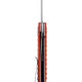 Spika Bushmaster Tango folding knife viewed spine-on, showing orange scales, liner and pocket clip