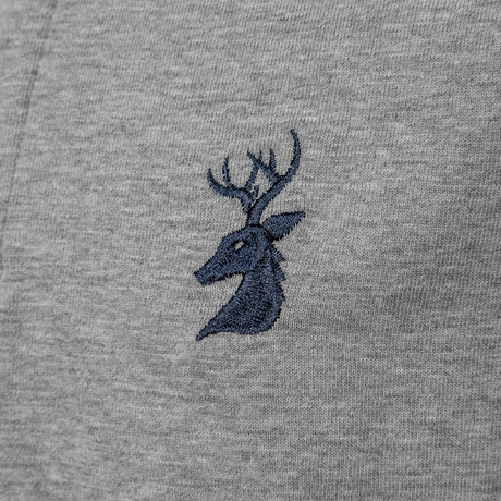 Close-up of the navy embroidered stag head logo on the Spika GO Advance kids' grey rugby jumper