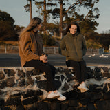 Two women sitting on a stone wall in jackets and Spika GO Ember women's black leggings