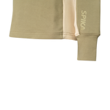 Close-up of the ribbed cuff, cream side panel and SPIKA sleeve print on Spika GO AVP women's olive half-zip