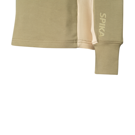 Close-up of the ribbed cuff, cream side panel and SPIKA sleeve print on Spika GO AVP women's olive half-zip