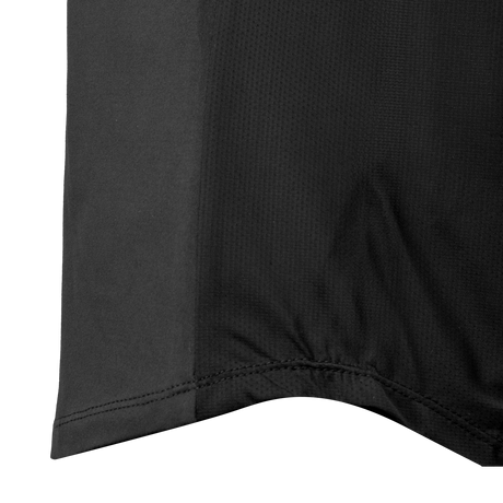 Close-up of the stitched curved hem and mesh side panel on the Spika GO AVP women's black half-zip