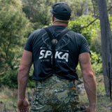 Hunter seen from behind in a Spika t-shirt with Edge Biarri Camo pants and braces in the bush