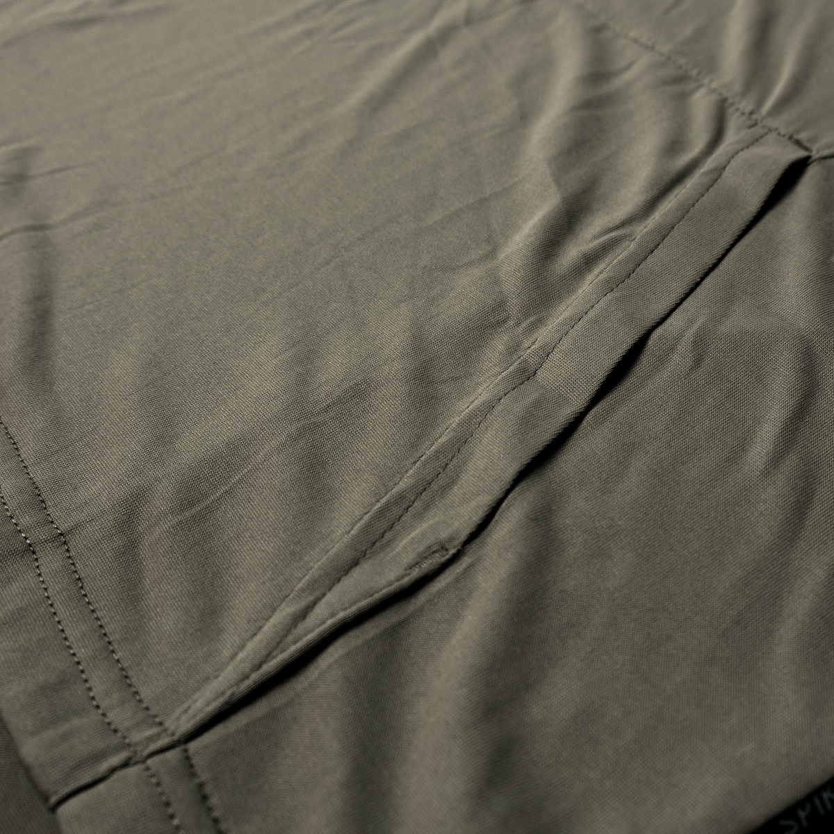 Spika Bandit youth hoodie close-up of the Moss Green fabric and kangaroo pocket stitching