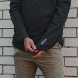 Close-up of the SPIKA logo on the cuff of the Spika GO Belay men's slate jumper worn with chinos