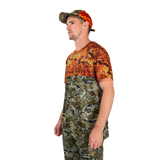 Man modelling the Spika Trail men's T-shirt in Biarri Blaze with a blaze cap, three-quarter view