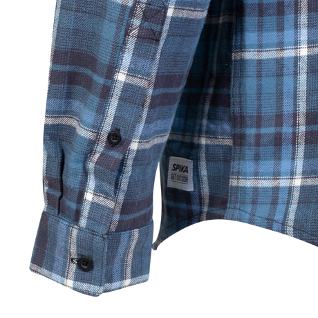 Spika men's Blue/Black flannel shirt close-up of the buttoned cuff and Get Outside hem tag