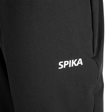 Close-up of the white SPIKA logo on the front thigh of Spika GO Casual women's black jogger pants
