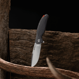 Spika Bushmaster Raider folding knife standing blade down against weathered timber and antler