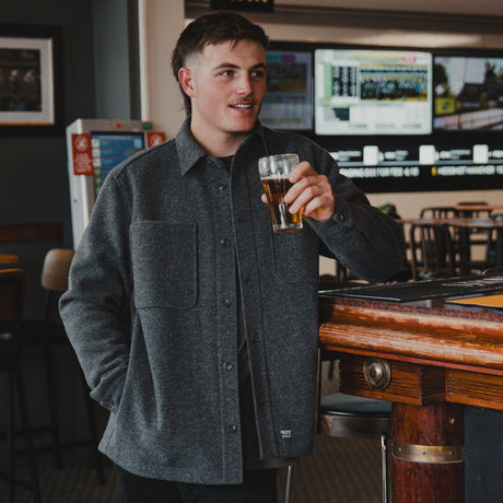 Man in the Spika GO Civvy men's slate shirt jacket holding a beer in a pub, waist-up view