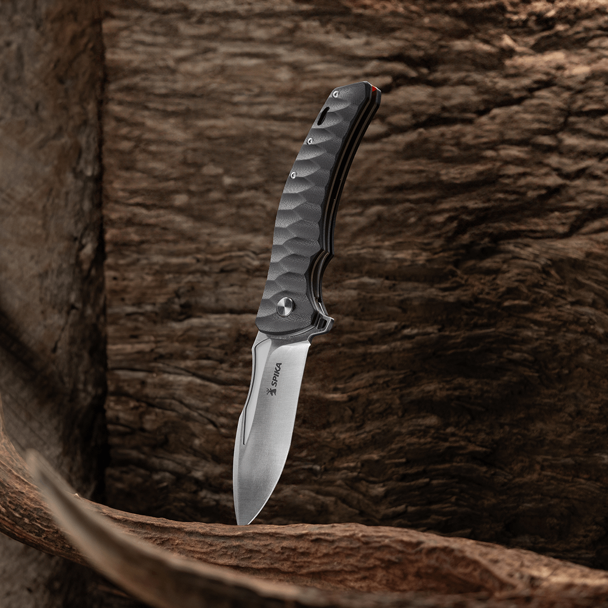 Spika Bushmaster Viper folding knife standing blade down against weathered timber and antler