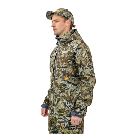 Man wearing the Spika Highpoint men's shell jacket in Biarri Camo, three-quarter view with cap