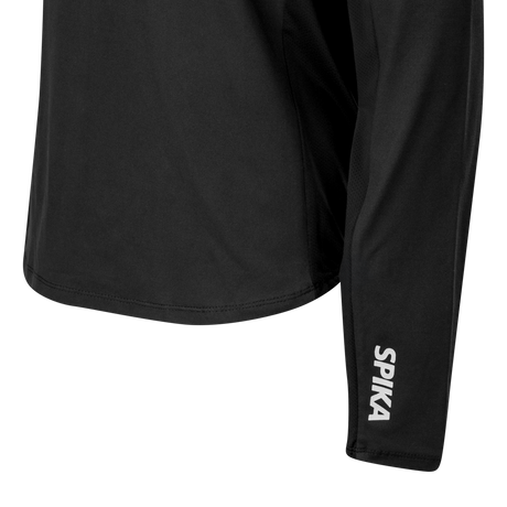 Close-up of the curved hem and reflective SPIKA cuff logo on the Spika GO AVP women's black half-zip